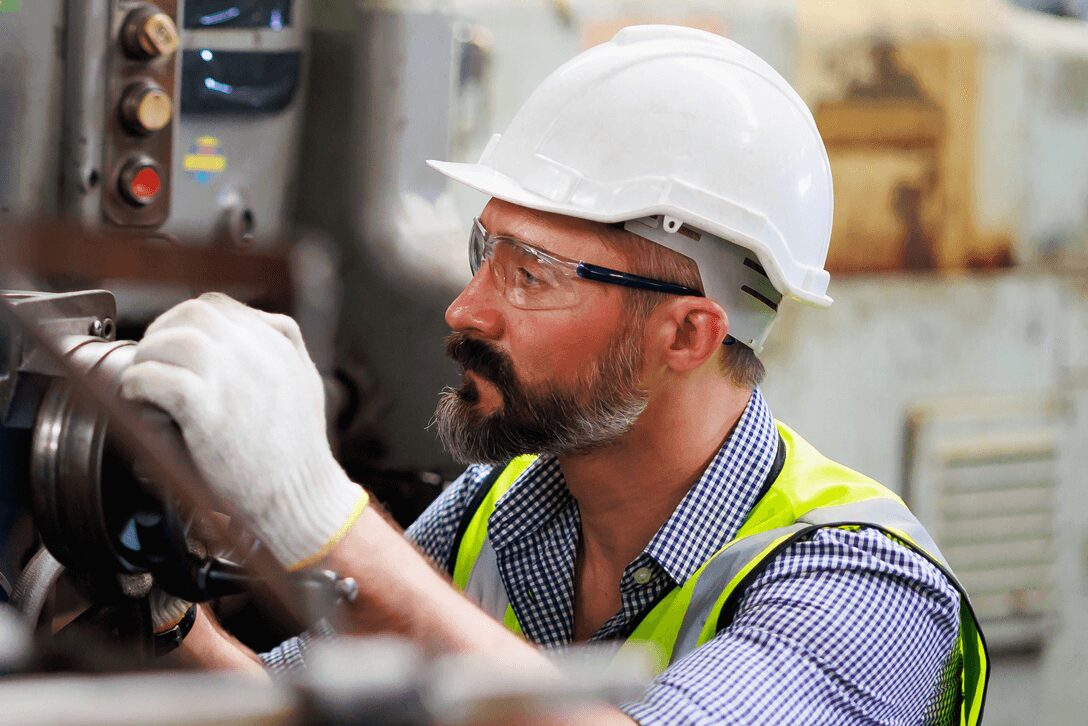 Foto di operatore industriale intento ad ispezionare un macchinario