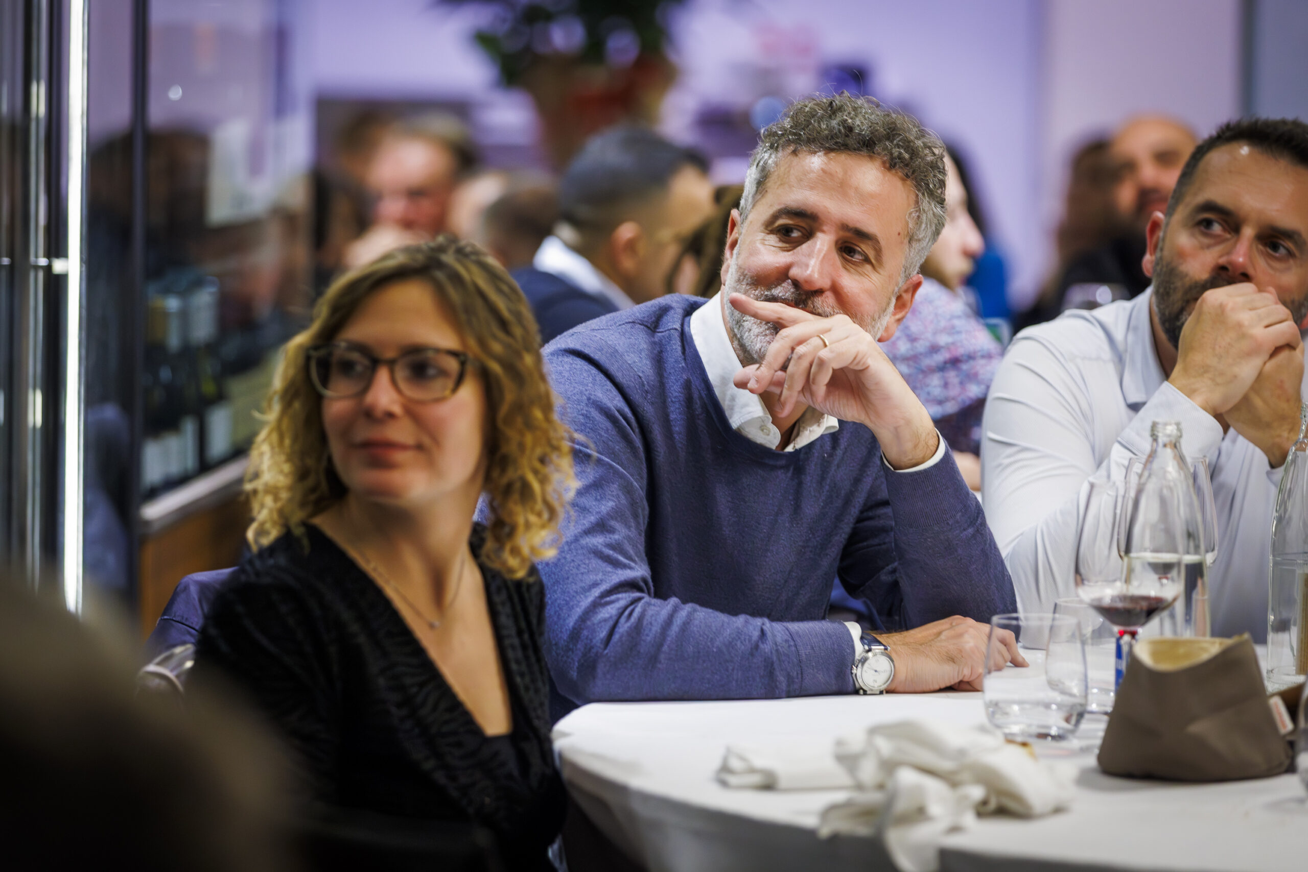 Dipendenti di Satech seduti al tavolo e in posa durante una festa aziendale, in un momento conviviale dell’evento.