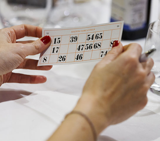 Momento di tombolata natalizia durante un evento aziendale, con i partecipanti coinvolti nel gioco.